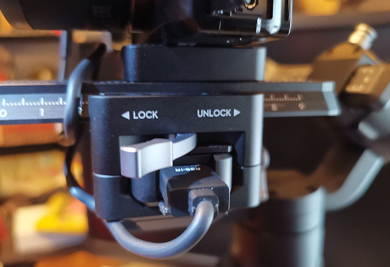 El perno para ajustar el carril en el que va montada la cámara. Debajo el conector para el microUSB o el emisor de infrarrojos